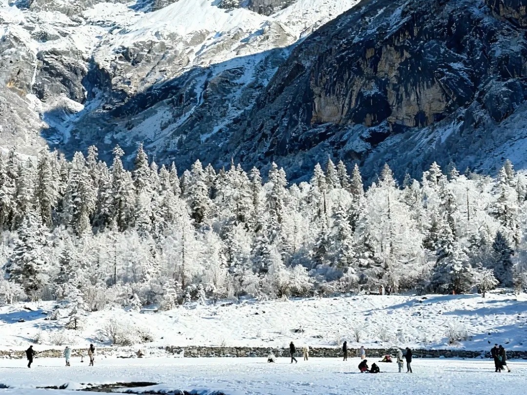 Snow-covered forests and majestic mountain peaks under a clear blue sky at Mount Siguniang in Sichuan, China